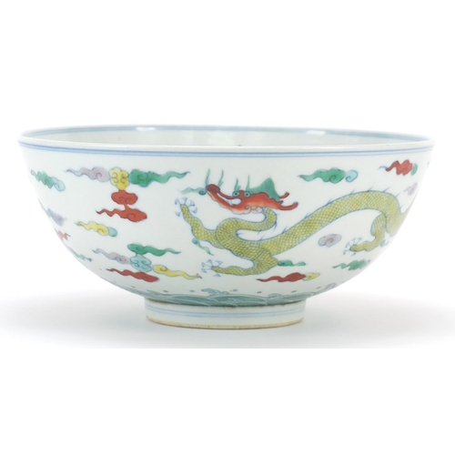 900 - Chinese doucai porcelain bowl hand painted with two dragons amongst clouds above crashing waves, six... 