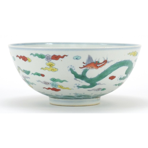 900 - Chinese doucai porcelain bowl hand painted with two dragons amongst clouds above crashing waves, six... 