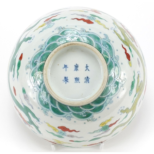 900 - Chinese doucai porcelain bowl hand painted with two dragons amongst clouds above crashing waves, six... 