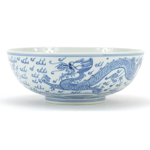 1050 - Chinese blue and white porcelain bowl hand painted with a dragon and phoenix amongst clouds, six fig... 