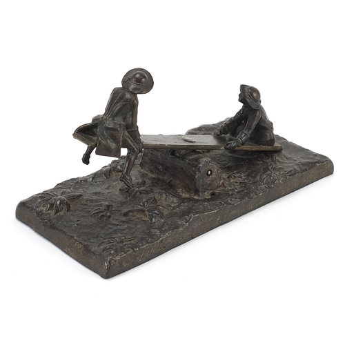 913 - 19th century bronzed metal letter clip in the form of two figures on a see-saw, 16.5cm wide