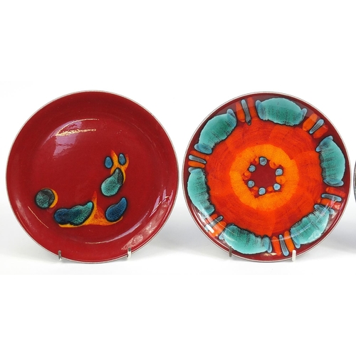 887 - Four Poole Pottery plates including Volcano and Odyssey patterns, each 21.5cm in diameter