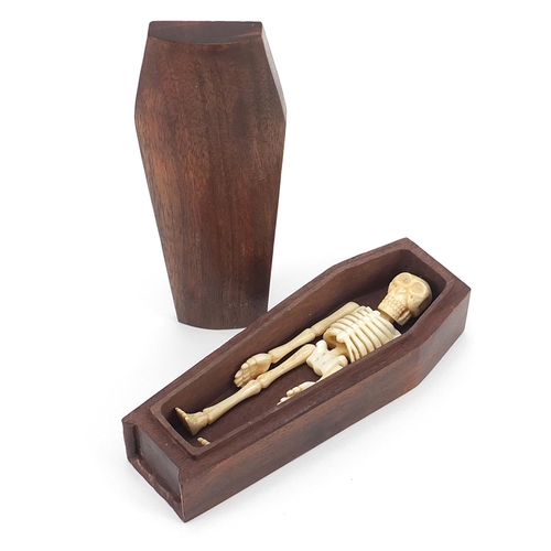 939 - Japanese carved wood coffin enclosing an articulated bone skeleton, 11.5cm high