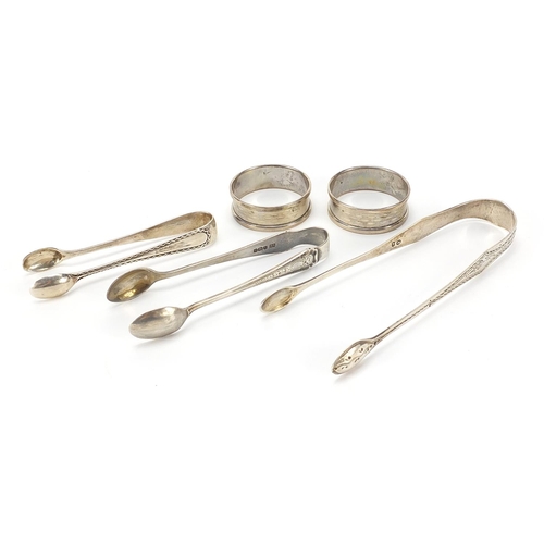 67 - Three pairs of Georgian and later silver sugar tongs and pair of circular silver napkin rings, the l... 