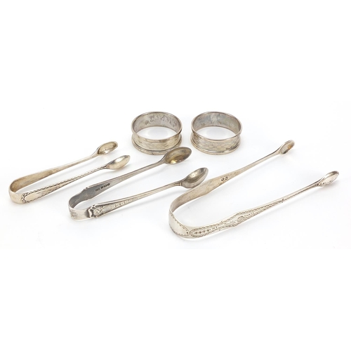 67 - Three pairs of Georgian and later silver sugar tongs and pair of circular silver napkin rings, the l... 