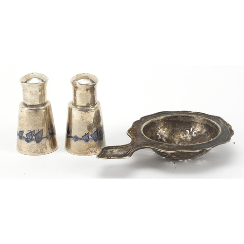 70 - Silver sifting spoon and a pair of niello work casters, the spoon 10.5cm in length, total 77.5g