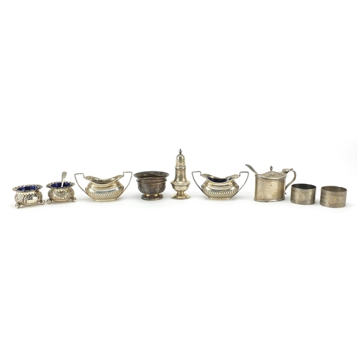 83 - Edwardian and later silver cruets and napkin rings, some with blue glass liners, weighable silver 34... 