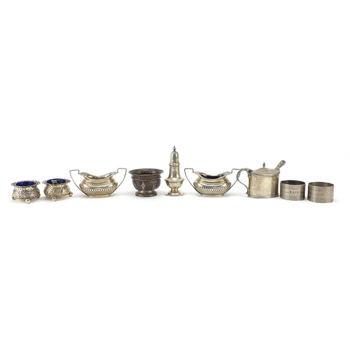 83 - Edwardian and later silver cruets and napkin rings, some with blue glass liners, weighable silver 34... 