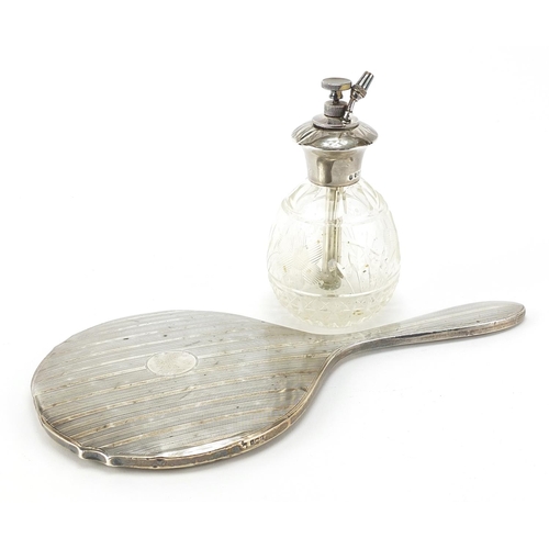 73 - George V silver backed hand mirror and cut glass atomiser with silver top, the largest 27cm in lengt... 