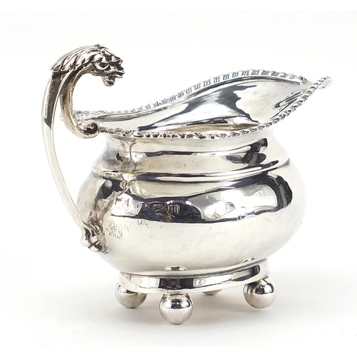 51 - Mappin & Webb, George V silver cream jug with griffin handle and ball feet, Birmingham 1911, 11cm in... 