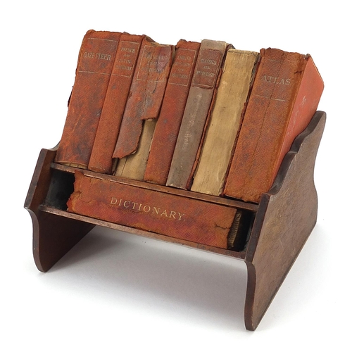 1009 - Miniature mahogany bookshelf housing eight books by Asprey of London, 20.5cm wide