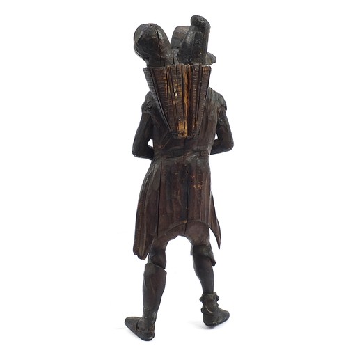 957 - Antique oak carving of a man holding a sack, 61cm high