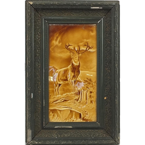 2126 - Large Victorian treacle glazed tile hand painted with a stag, framed, the tile 29cm x 14.5cm excludi... 