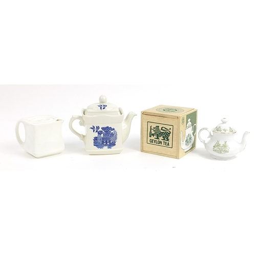 180 - Three collectable teapots including a cubed teapot, blue and white Willow pattern and a boxed Mensa ... 