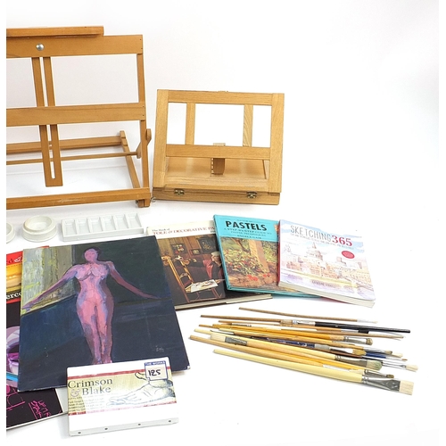 162 - Wooden artist's easels, paint brushes, canvasses, paper and articulated models, the largest easel 52... 