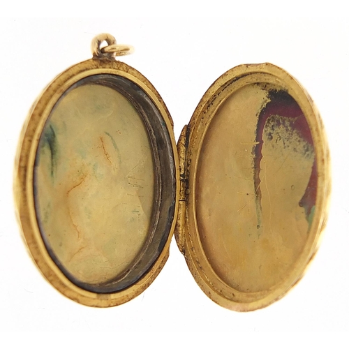 117 - Unmarked gold oval locket with engraved decoration, 3.2cm high, 7.7g