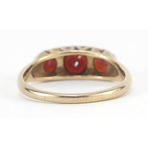 349 - 9ct gold garnet three stone ring, size O, 2.5g