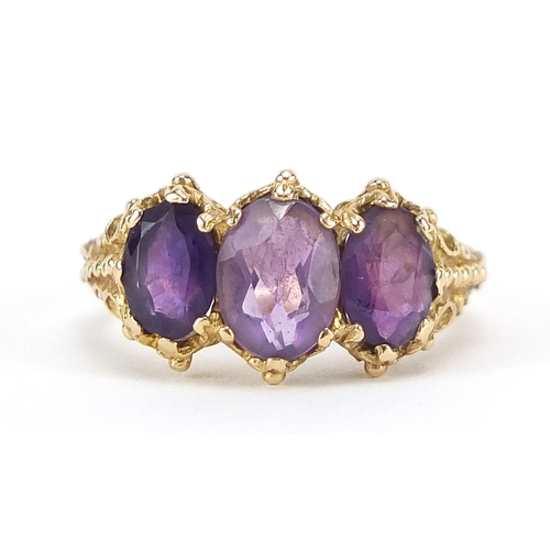 80 - 9ct gold amethyst three stone ring with ornate shoulders, size M, 3.9g