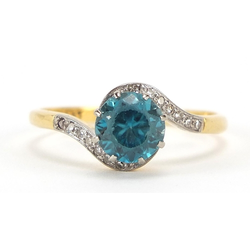 68 - 18ct gold and platinum blue stone and diamond crossover ring, possibly aquamarine, size R, 3.6g