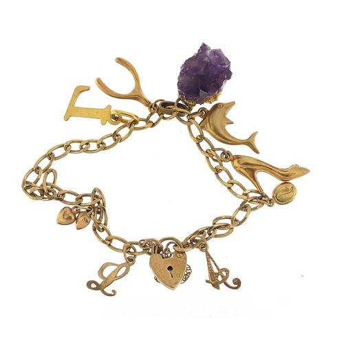 52 - 9ct gold charm bracelet with a selection of 9ct gold charms, unmarked gold charms and an amethyst sp... 