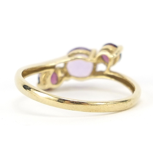 218 - 9ct gold purple stone crossover ring, size S, 2.0g