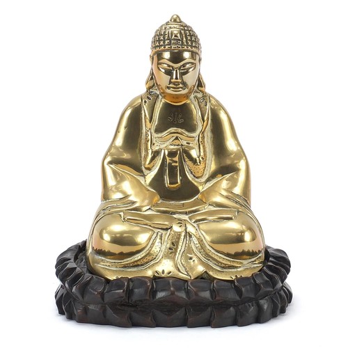 140 - Chinese bronzed figure of Buddha raised on a carved hardwood lotus stand, 23.5cm high