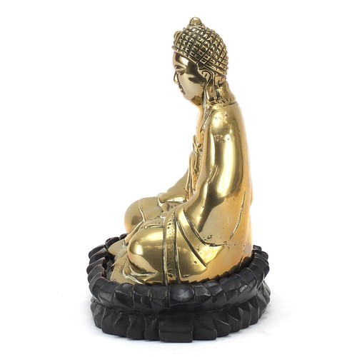 140 - Chinese bronzed figure of Buddha raised on a carved hardwood lotus stand, 23.5cm high