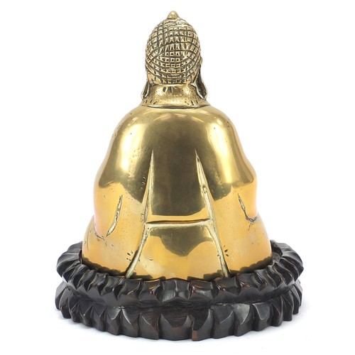 140 - Chinese bronzed figure of Buddha raised on a carved hardwood lotus stand, 23.5cm high