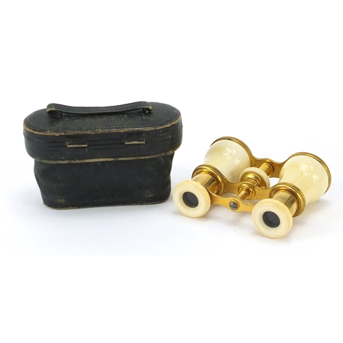 11 - Pair of 19th century gilt brass and ivory opera glasses with tooled leather silk lined case, 7cm wid... 