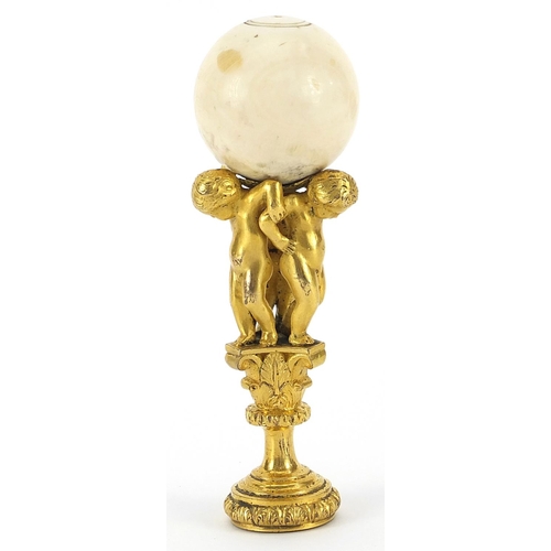 9 - 19th century turned ivory, gilt bronze and agate desk seal cast with three nude children, 11cm high