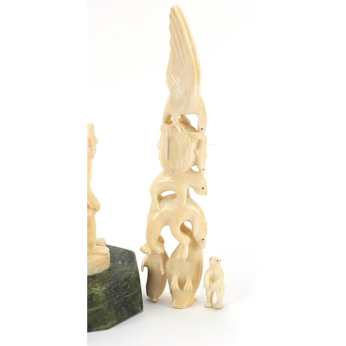 12 - Inuit ivory carving raised on a green hardstone base, the largest piece 24cm high