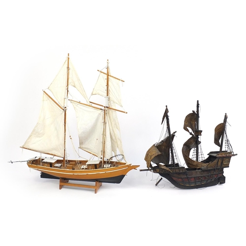 68 - Wooden model of a galleon and wooden yacht with cloth sails, the largest 63cm in length