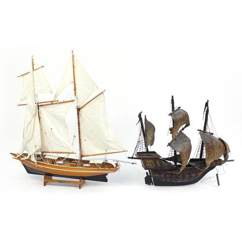 68 - Wooden model of a galleon and wooden yacht with cloth sails, the largest 63cm in length