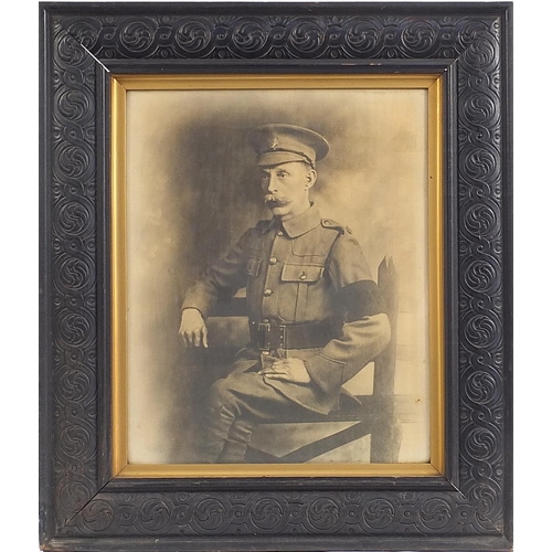 229 - Black and white print World War I military soldier in uniform, mounted in a carved oak frame, overal... 