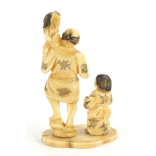 19 - Japanese carved ivory okimono of a father and two children, 11.5cm high