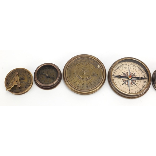 664 - Four brass nautical interest compasses and sun dials, the largest 7.5cm in diameter