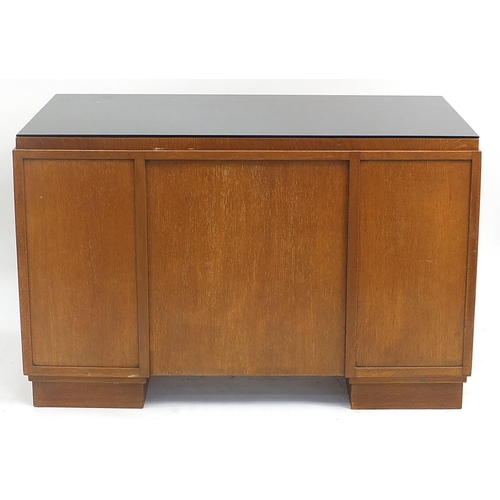 840 - Manner of Heals, Art Deco oak desk with lift of glass top and two doors enclosing drawers and shelf ... 