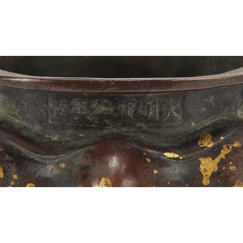 203 - Chinese gold splashed patinated bronze tripod censer with twin handles, 16cm wide