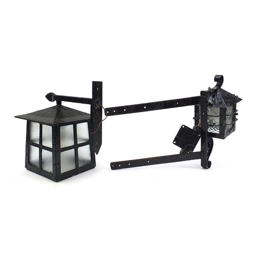 1153 - Two black painted wrought metal wall lanterns, the largest 34cm high