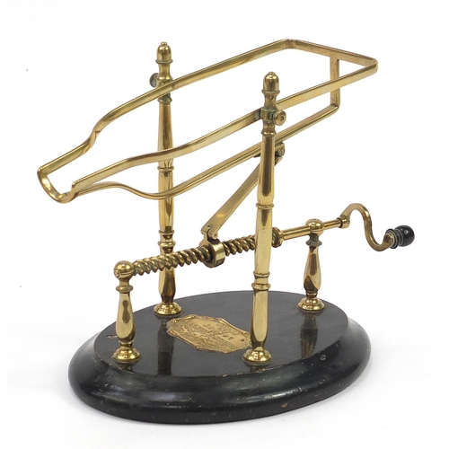 40 - Farrow & Jackson of London & Paris, 19th century brass mechanical wine cradle with an ebonised base,... 