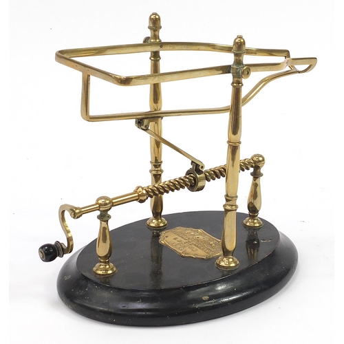 40 - Farrow & Jackson of London & Paris, 19th century brass mechanical wine cradle with an ebonised base,... 
