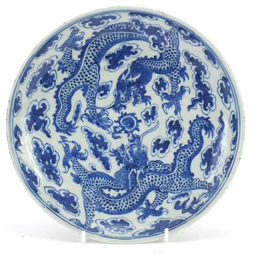 23 - Chinese blue and white porcelain plate hand painted with two dragons chasing a flaming pearl amongst... 
