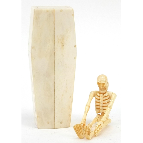 601 - Carved bone miniature coffin housing an articulated human skeleton, 11.5cm in length