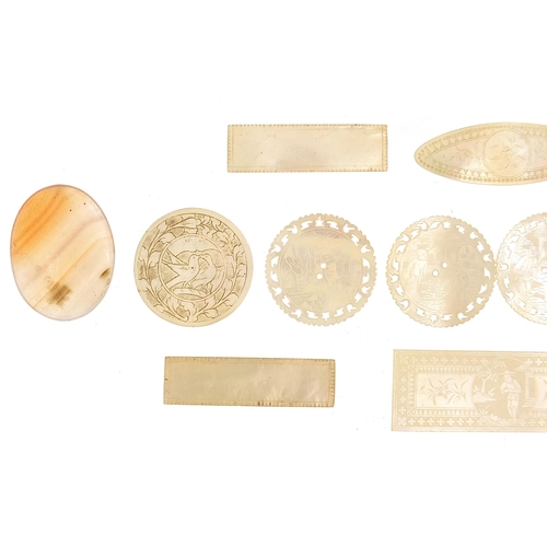 692 - Eleven Chinese carved mother of pearl gaming tokens and three polished stones, the largest 6cm in le... 