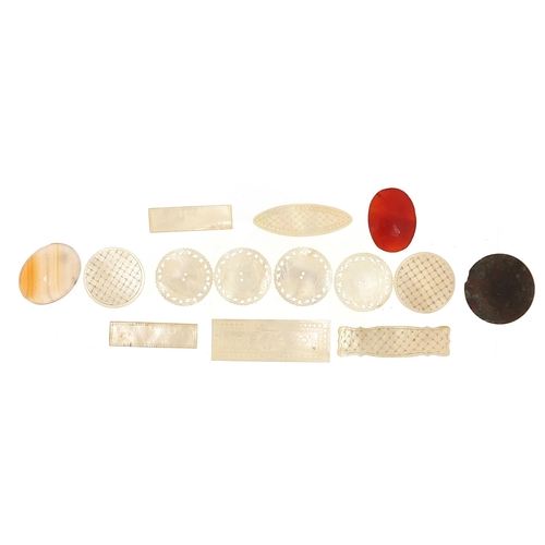 692 - Eleven Chinese carved mother of pearl gaming tokens and three polished stones, the largest 6cm in le... 