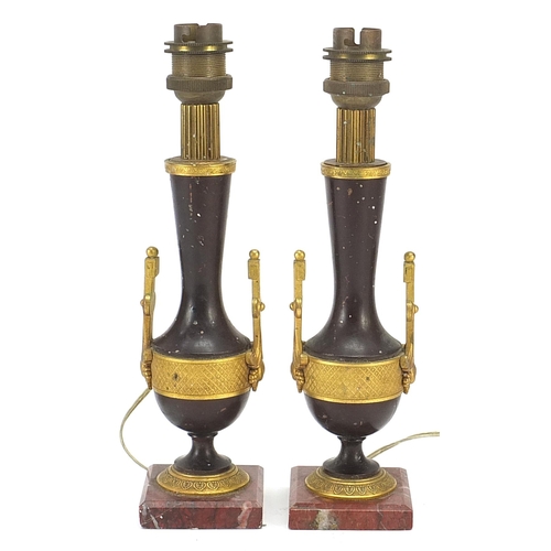 2 - Pair of French patinated bronze and ormolu candlesticks converted to table lamps, each raised on rou... 