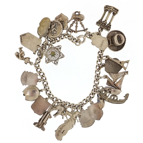 2052 - Silver charm bracelet with a selection of mostly silver charms including bagpipes, clogs and gondola... 