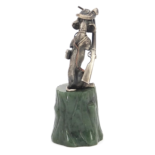 2227 - Novelty silver model of a seated gundog with ruby eyes, raised on a green jade tree stump, 8cm high,... 