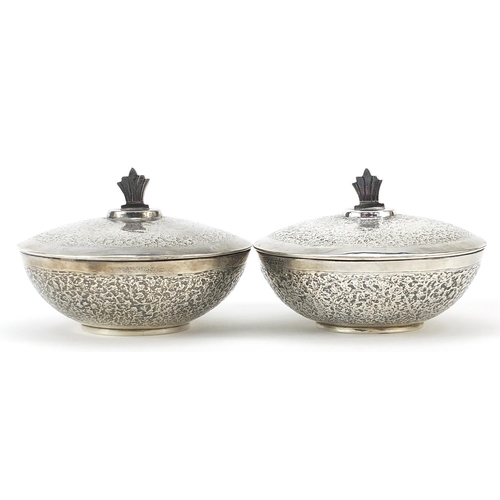 2257 - Pair of circular Burmese silver lidded bowls profusely embossed with vines, 11cm in diameter, 344.0g