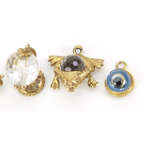 1820 - Five gold charms including crystal frog and globe and a dragon claw with pearl, the largest 1.5cm hi... 